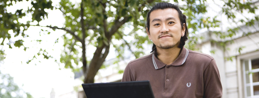 International student using a laptop on campus 