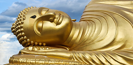a gold statue of a resting buddha