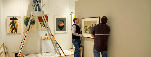 Hanging paintings in the the Stanley & Audrey Burton Gallery