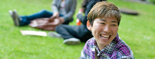 Smiling student sitting on the grass