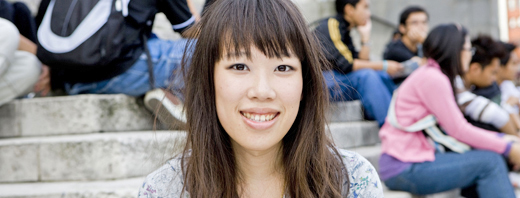 An international student sits outside the Parkinson Building