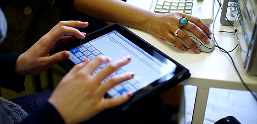 Students using an iPad and desktop PC