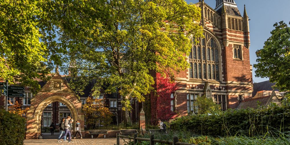 Students walking past the Great Hall on a sunny day