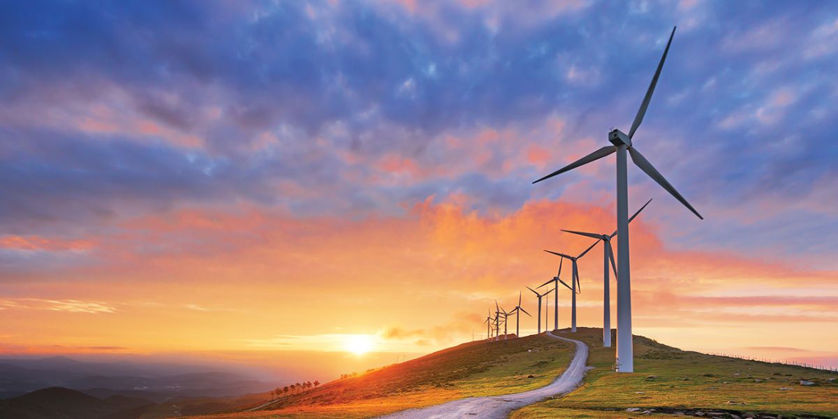 Wind turbines on a hill at sunset