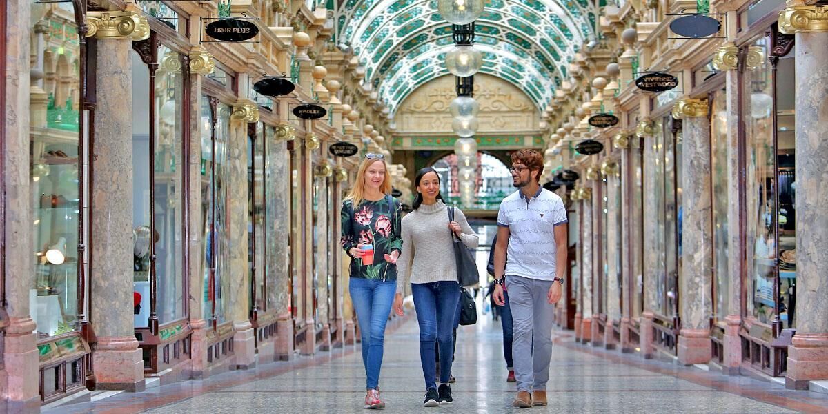 Three students walking in the Victoria Quarter in Leeds.
