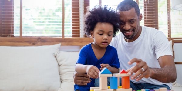 A child and their parent playing with toy blocks