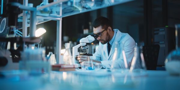 Scientist looks through a microscope in a laboratory