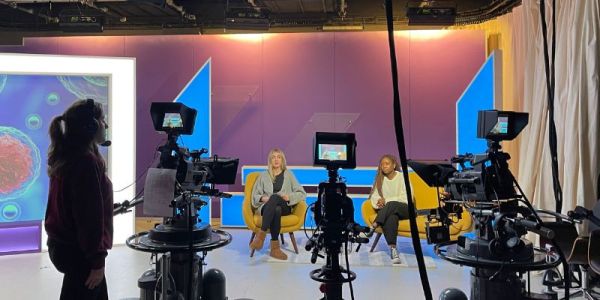 Three journalism students in the former Channel 4 set at the School of Media and Communication, University of Leeds