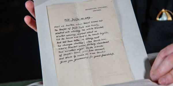 Hands carefully holding ‘Mód Þrýþe Ne Wæg’, a handwritten manuscript by CS Lewis