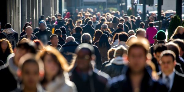 A large crowd of people walking on a busy road