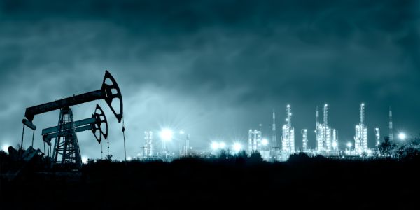 Oil rigs at night, with industrial towers lighting the background.