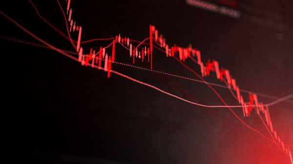 A graph with a red line going down, representing stock prices falling