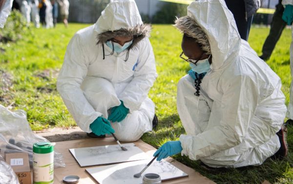 Pupils from Leeds City Academy use brushes to detect fingerprints at a mocked-up crime scene.