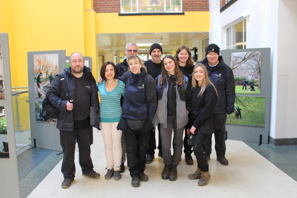 A photo of a group of people stood in a corridor with photography exhibition to the sides of them