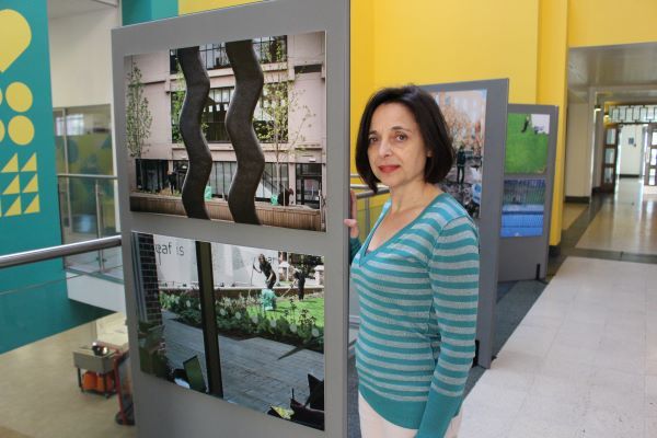 Rosa stood next to two of her photos on an exhibition board
