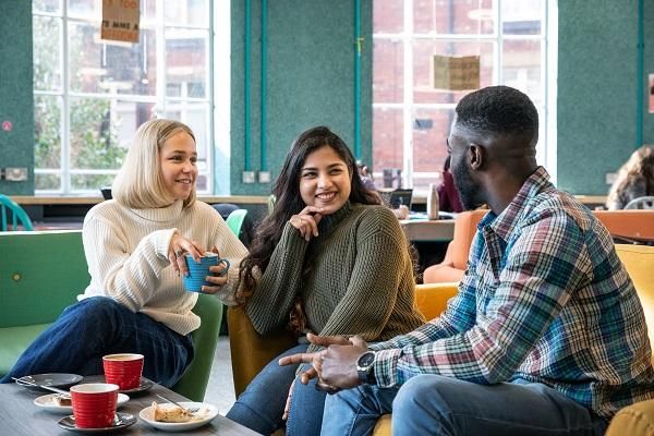 A group of students talk to one another in a cafe.