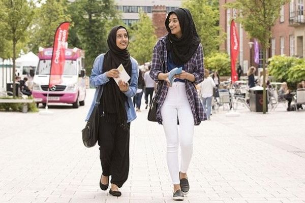 Two students walking together on an open day outside Leeds University Union.