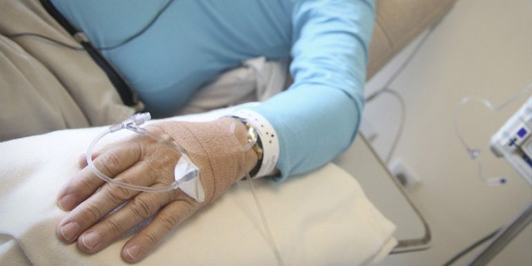 A cannula attached to a man's hand to deliver medication