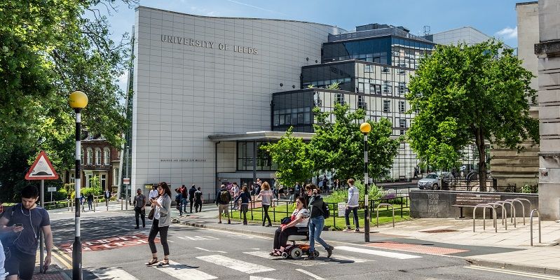 People walking around outside the Albert and Marjorie Ziff building on a sunny day