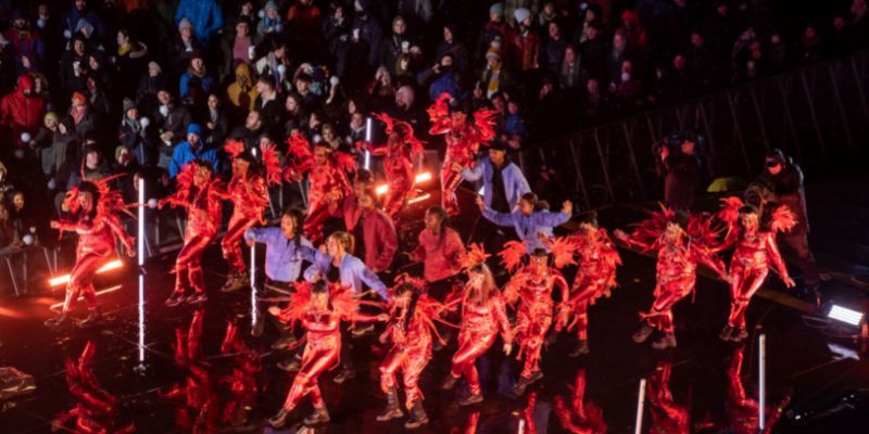 Carnival dancers in spectacular red outfits perform on the catwalk stage at LEEDS 2023's 'Awakening' event.