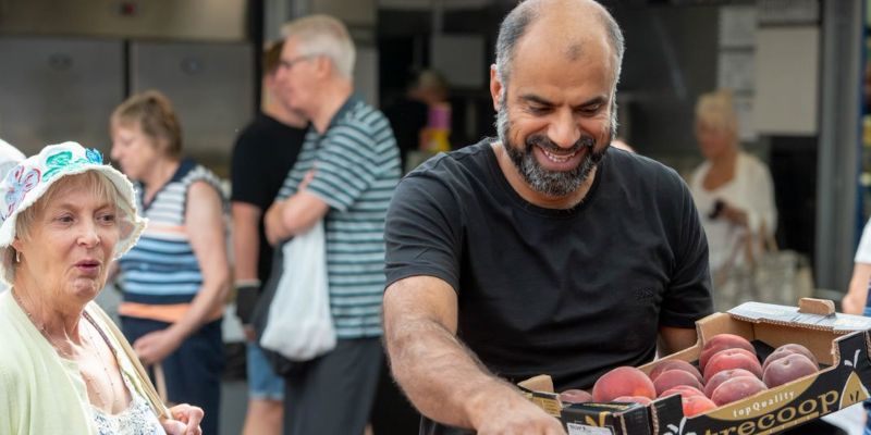 A customer buying fruit from a stall in Bury Market