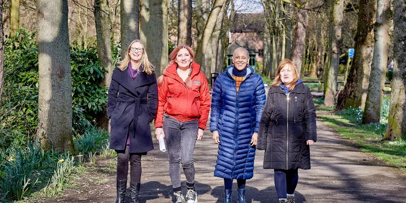 Four women walk along a tree-lined path in Clarence Park, Wakefield.