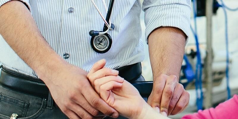 A health professional taking a patient's pulse