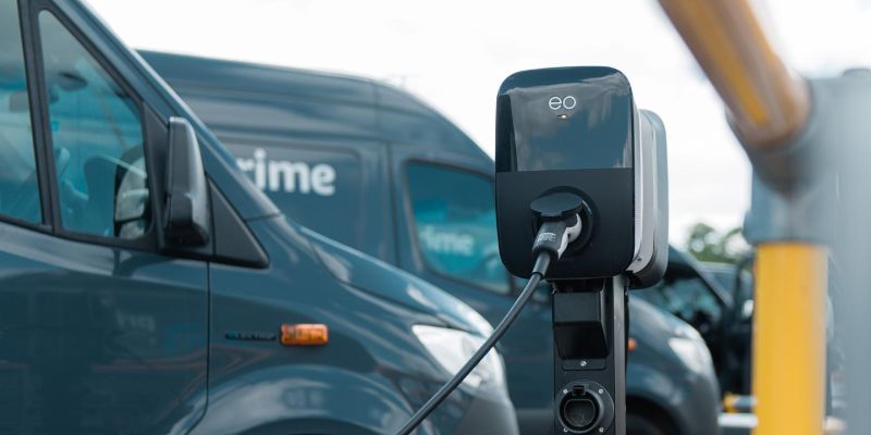 An Amazon delivery van charges at an electric charging station