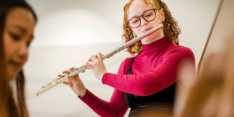 Ellena playing the flute, another student is in the photo