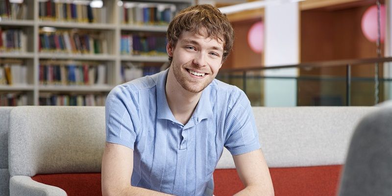 George Hobley sat in a study space and smiling at the camera