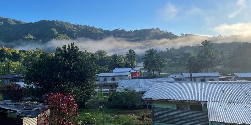 The village of Waibasaga in Fiji with houses in the foreground and mountains in the background.