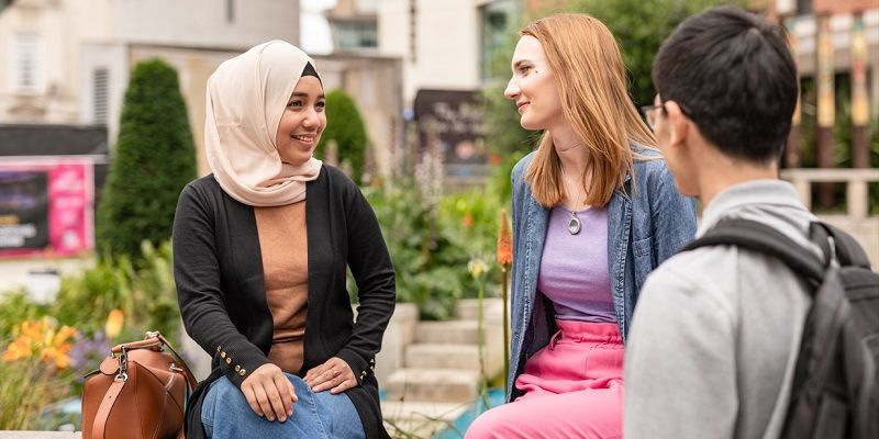 Three international students chatting in millennium square