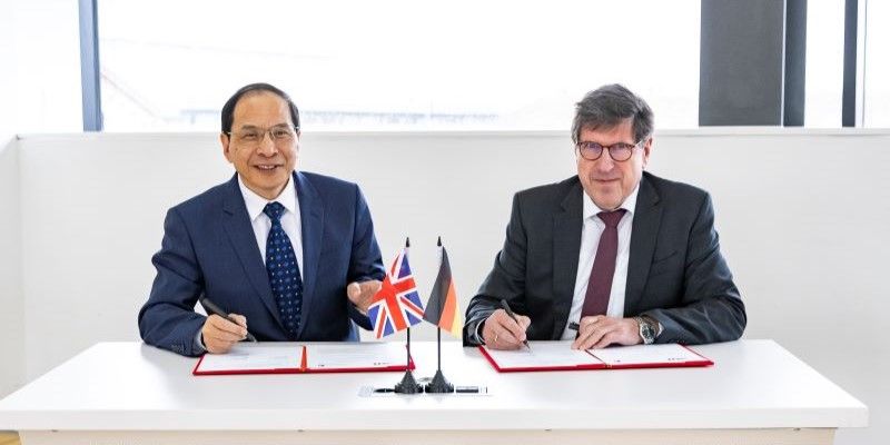 Professor Hai-Sui Yu, Provost and Deputy Vice-Chancellor of the University of Leeds, and Professor Thomas Hirth, Vice-President Transfer and International Affairs at Karlsruhe Institute of Technology sit at a table with signed documents.