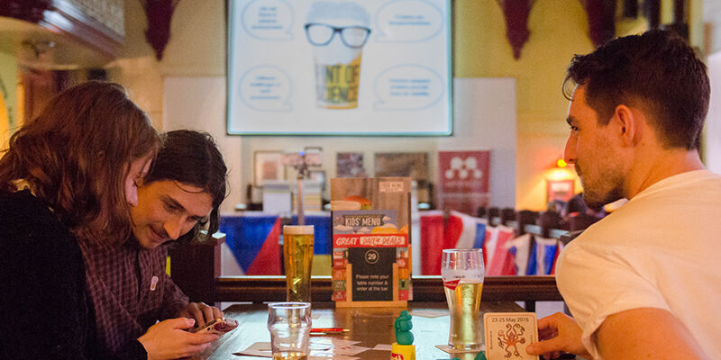 young adults smiling in a pub listening to a scientific talk