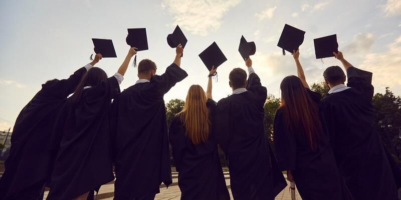 Students throwing their academic mortar boards into the air.