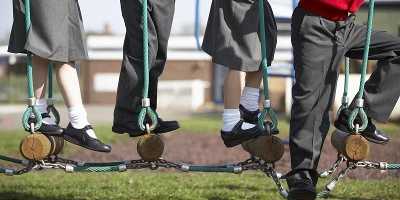 Children in school uniform on a climbing frame