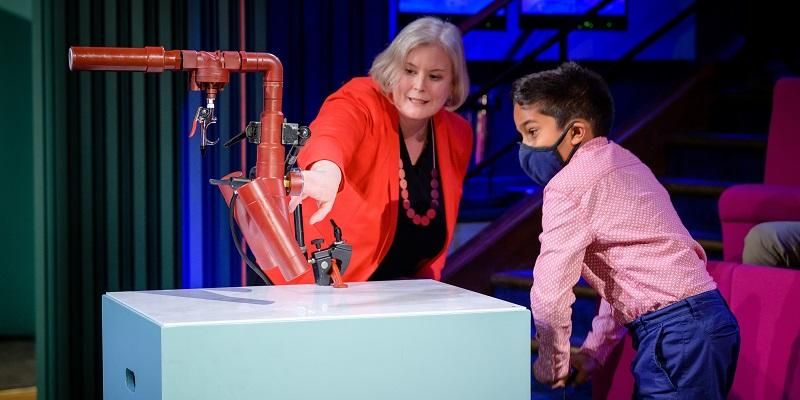 Professor Cath Noakes with a member of the audience  doing an experiment