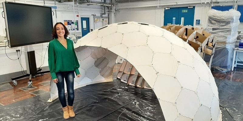 Professor Ornella Iuorio stands by the side of a dome structure constructed in a laboratory