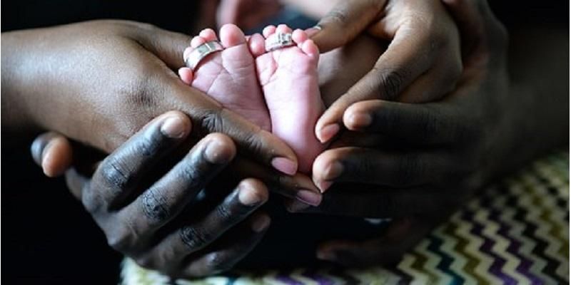 Baby being held by its parents or carers