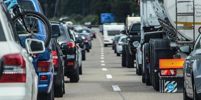 Two lanes of stationary traffic. In the distance is a blue-coloured motorway sign.