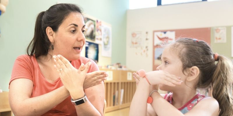 a teacher and child using sign language