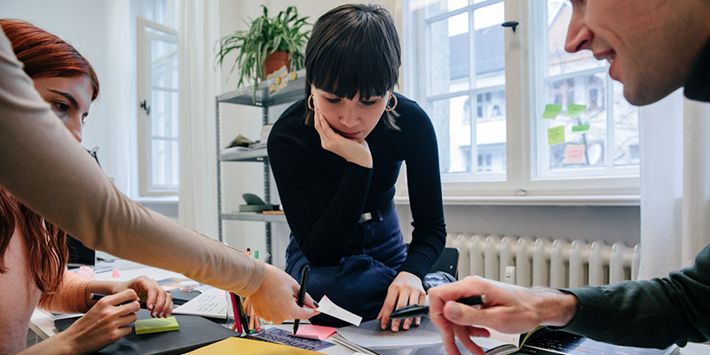 Three people working as a team around a table