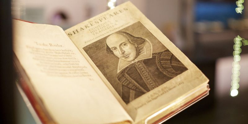A Shakespeare First Folio book open and showing a portrait of William Shakespeare