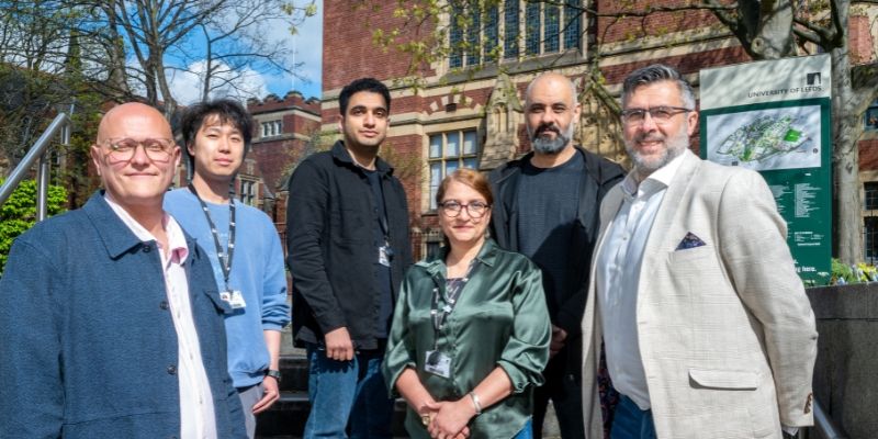 Group of people standing in front of red-brick University building