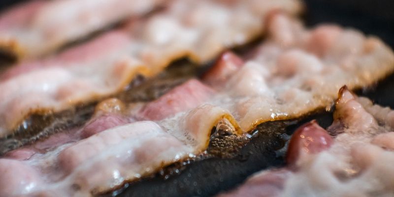 Rashers of bacon being cooked