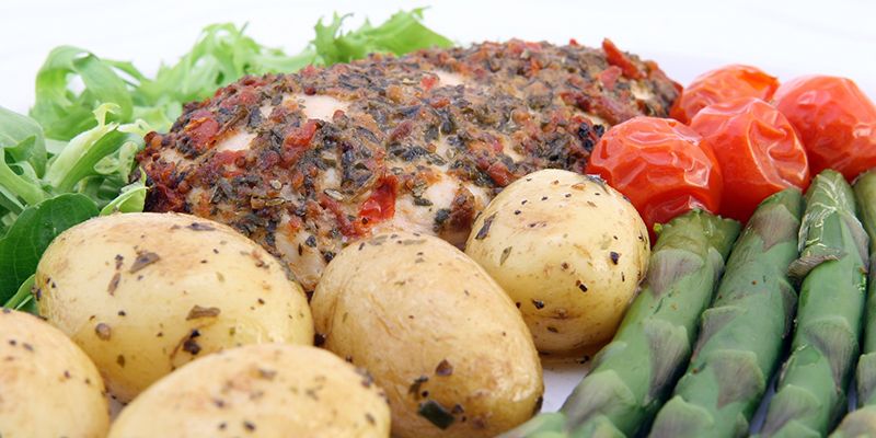 Cooked chicken breast with potatoes, tomatoes and asparagus