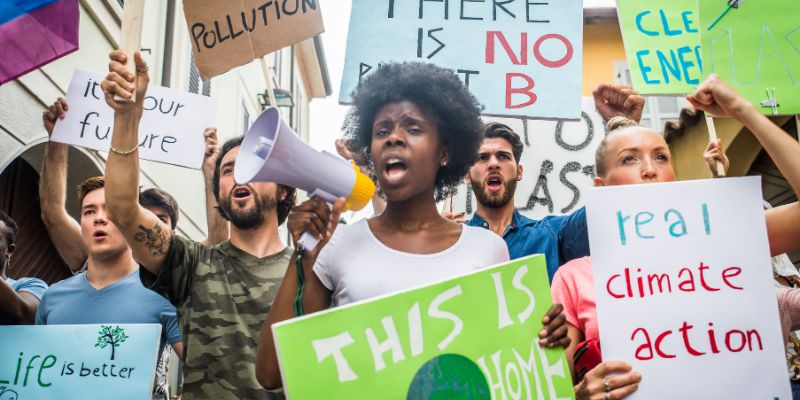 A group of people take part in a climate change protest, carrying banners