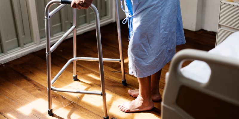 An elderly person using a walking frame