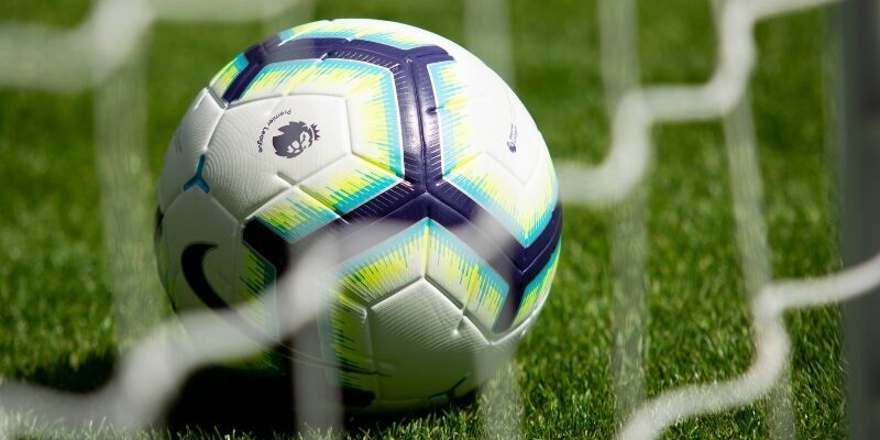 A football inside a goal net.