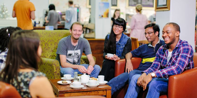 Group of students laughing in a cafe